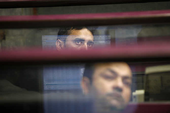 Brokers monitor the market from their booth during a trading session at the Karachi Stock Exchange, Pakistan.