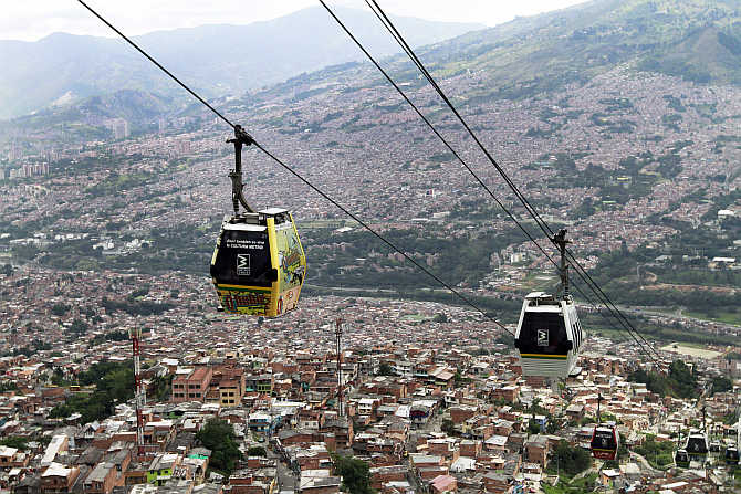 Cable cars pass above the town of Medellin, Colombia.