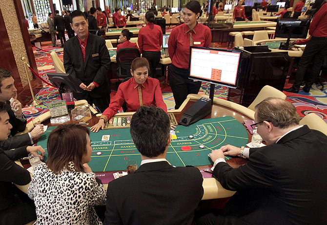 Foreigners play on a baccarat table during the opening of Solaire Casino-Resort in Pasay city, Metro Manila.