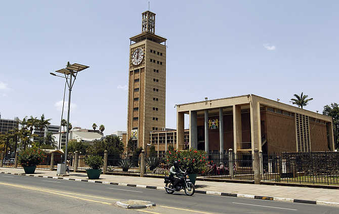 A motorcyclist rides past the Kenyan Parliament House clock tower in the capital Nairobi.