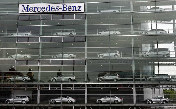 Mercedes-Benz cars are displayed in the windows of a dealership of German car manufacturer Daimler in Munich, Germany.