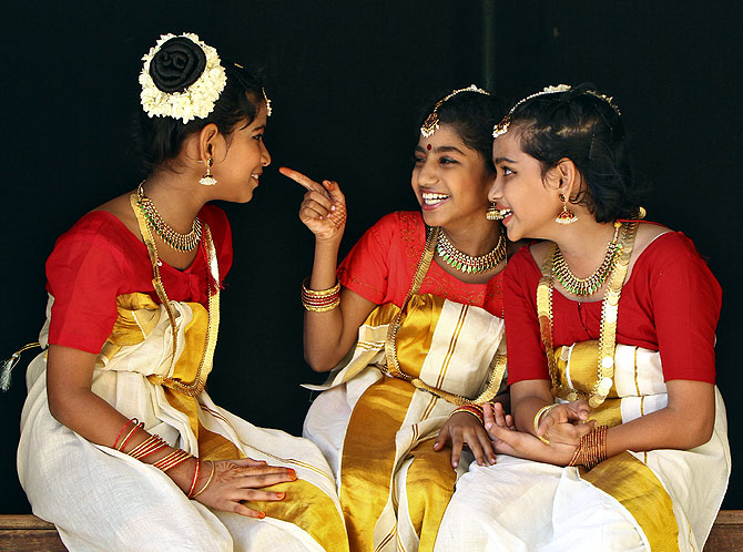 School girls wearing traditional costume share a laugh backstage as they wait to perform during festivities marking the start of the annual harvest festival of Onam in the southern Indian city of Chennai.