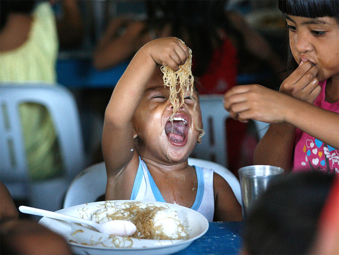 A boy enjoys free meals during a feeding program at a slum community.