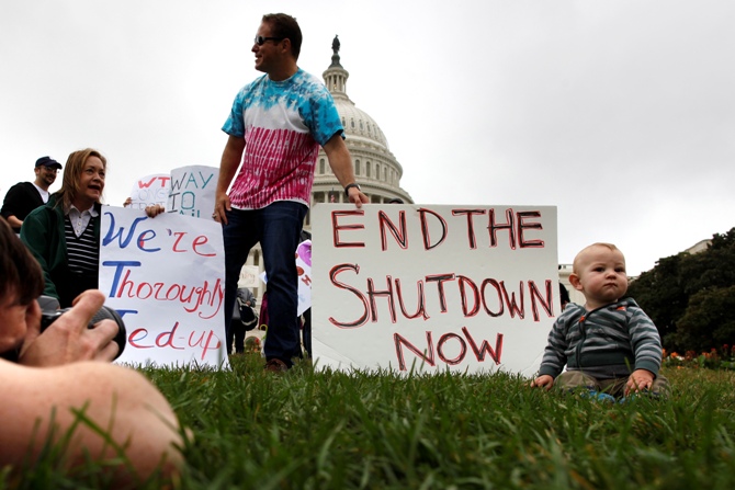 Mason Palmer (right), 10 months old, has his picture taken by his father in front of federal workers demonstrating for an end to the US government shutdown on the west front of the US Capitol in Washington.