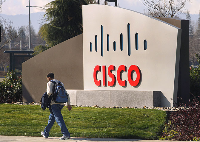 A pedestrian walks past the Cisco logo at the technology company's campus in San Jose.