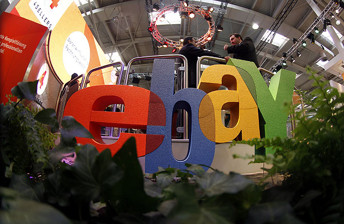 Visitors chat next to the Ebay logo at the CeBIT computer fair in Hanover.