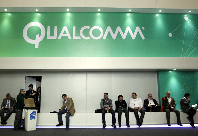 People sit next a Qualcomm stand at the Mobile World Congress at Barcelona.