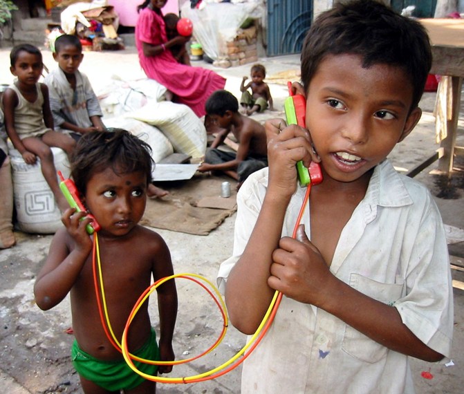 In this file photo, two Indian street children talk to each other through a toy phone in Kolkata.