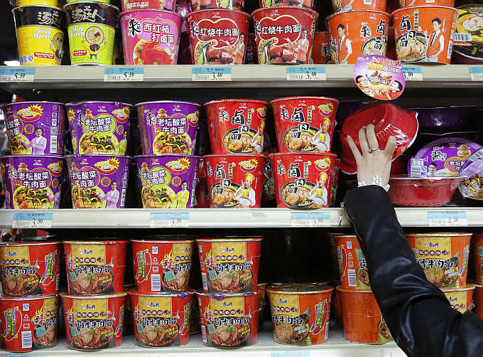 A woman chooses a cup noodle from a shelf at a supermarket in Beijing, China. Photo is for representation purpose only.