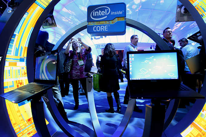 A woman takes a photo of ultrabooks at the Intel booth during the International Consumer Electronics Show in Las Vegas, Nevada.