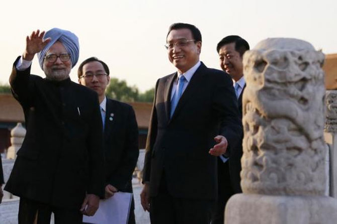  China's Premier Li Keqiang (2nd R) gestures as Prime Minister Manmohan Singh (L) waves during their visit to the Forbidden City, in Beijing, October 23, 2013.