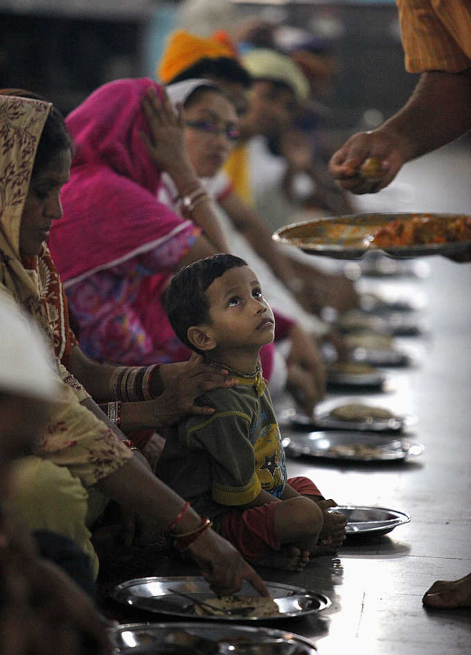 A boy waits for his meal at a community kitchen at a Sikh temple in the old quarters of Delhi.