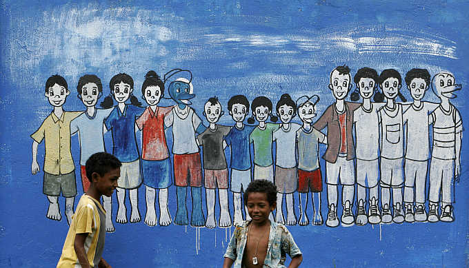 East Timorese children play near a mural in capital Dili.