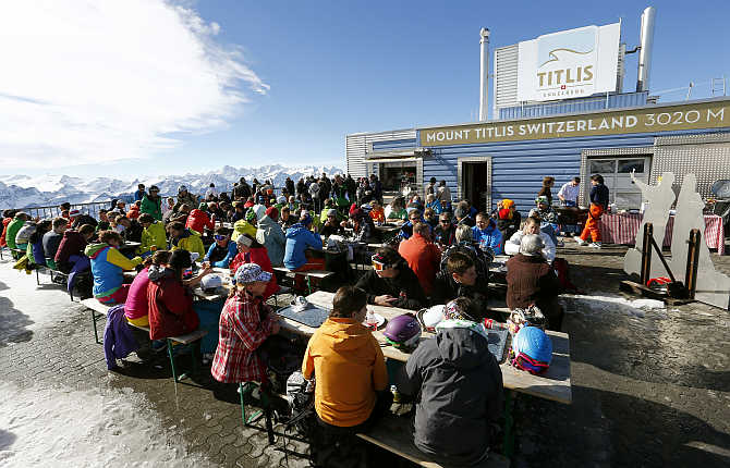 Skiers and tourists sit at a restaurant terrace at the mountain station of the Mount Titlis cablecar (3,020 metres) near the mountain resort of Engelberg, Switzerland.