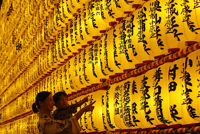 A family looks at paper lanterns during the Mitama Festival at Yasukuni Shrine in Tokyo, Japan.
