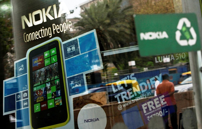 A man is reflected on the glass door of a Nokia showroom in New Delhi.