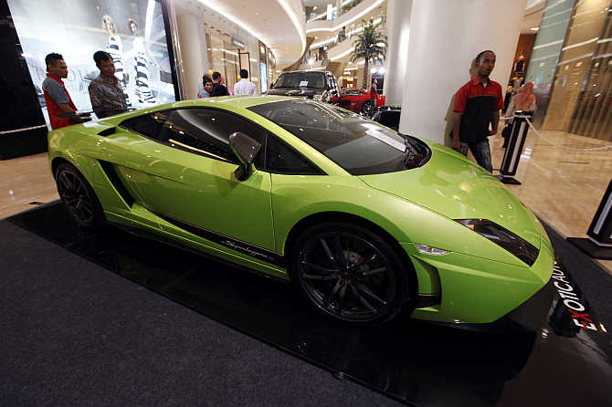 Men look at a Lamborghini on display at a shopping mall in Jakarta, Indonesia.