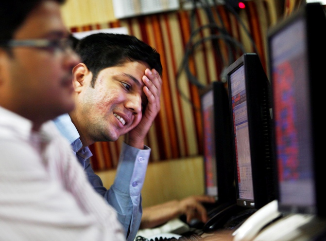 A dealer reacts while trading at a stock brokerage firm in Kolkata.