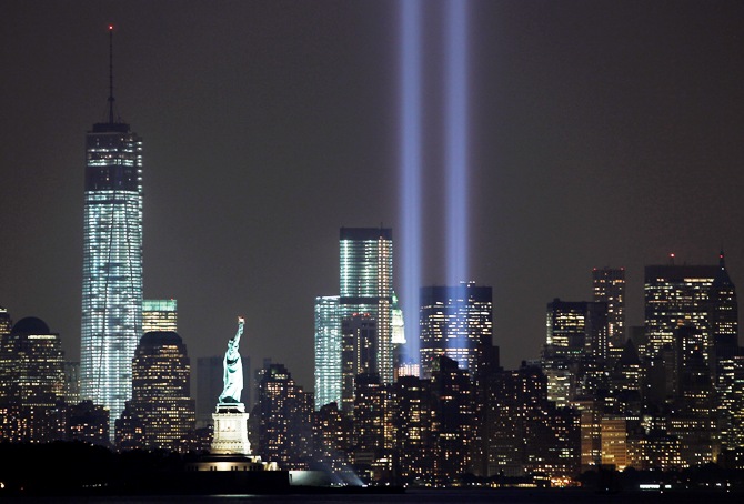 The Tribute in Light is illuminated next to the Statue of Liberty (C) and One World Trade Center (L) during events marking the 12th anniversary of the 9/11 attacks on the World Trade Center in New York, September 10, 2013.