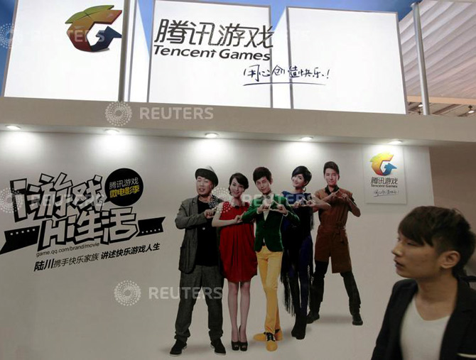 A man walks past in front of a booth of Tencent Games during the 10th China International Digital Content Expo in Beijing.