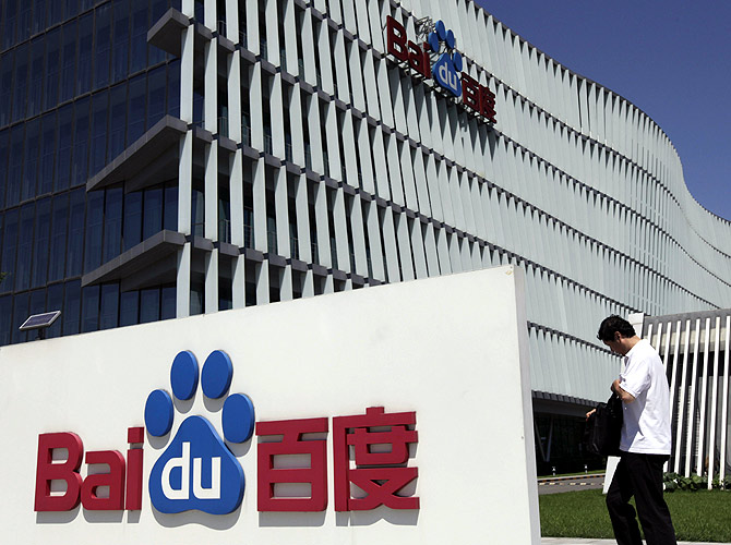 An employee walks past the Baidu company signage outside its headquarters in Beijing.
