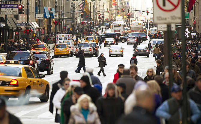 Pedestrians walk across 5th Avenue while shopping in New York City, United States.