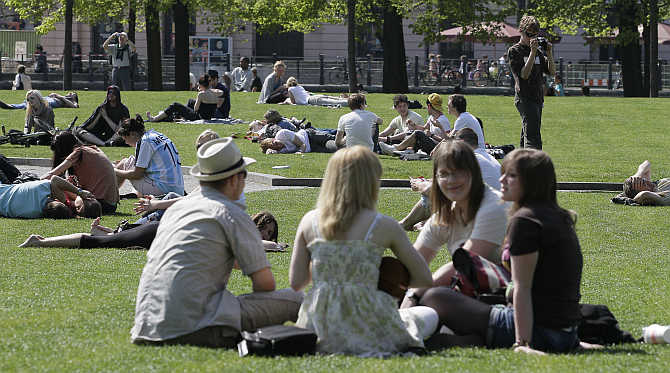 People enjoy a sunny day at a public square downtown Berlin, Germany.