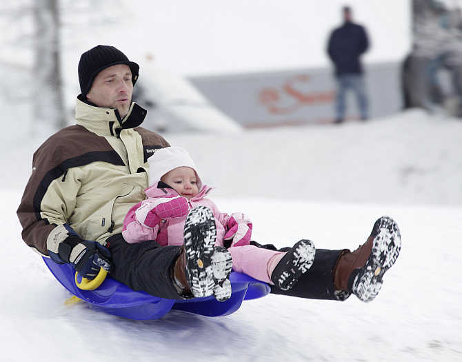 People enjoy sledging in the snow at the Chalet-a-Gobet in Lausanne, Switzerland.