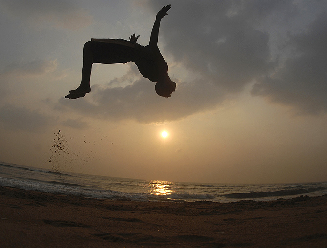 A boy somersaults at Marina beach as part of his routine morning exercise in Chennai.