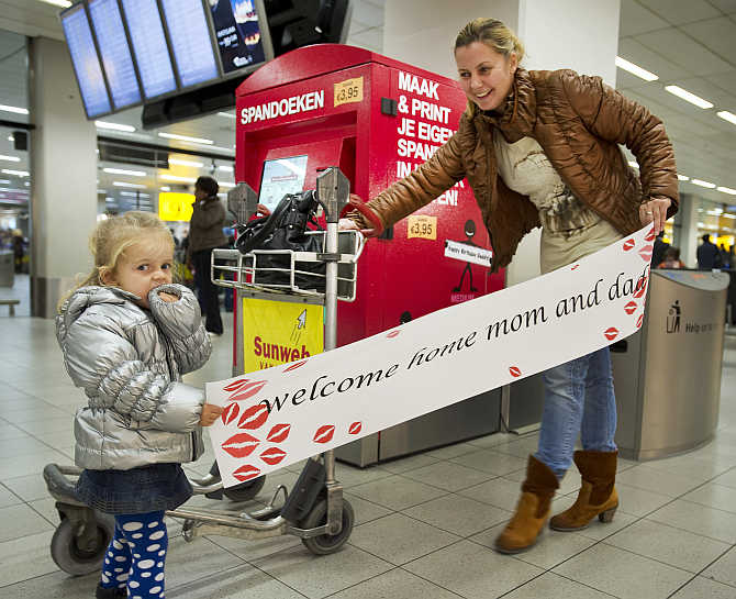 Two-year-old Luna and her aunt hold a banner at Amsterdam Airport Schiphol, the Netherlands. They created the banner using a banner machine which was designed by the Amsterdam company BannerXpress Ltd. Schiphol Airport is the first airport in the world with a banner device.