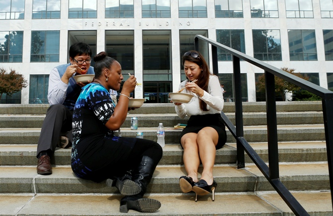 Workers have lunch on the steps of a federal in Washington October 17, 2013.