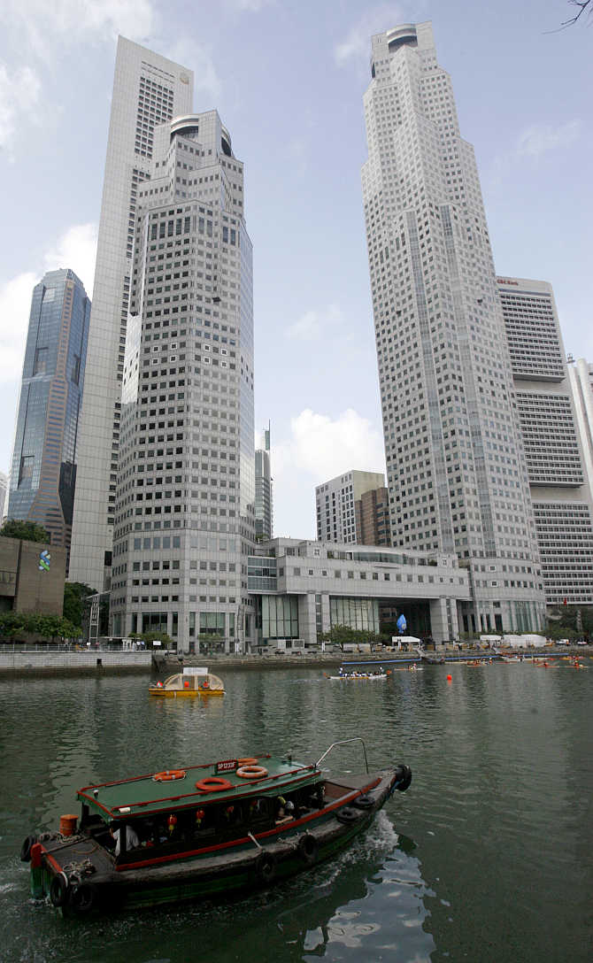 A boat sails past office buildings in Singapore.