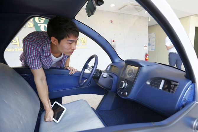 A researcher looks at the interior of Armadillo-T, a foldable electric vehicle, at the Korea Advanced Institute of Science and Technology (KAIST) in Daejeon, south of Seoul.