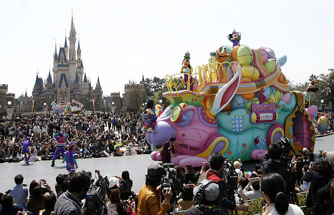 Mickey Mouse, top, performs atop a float at Tokyo Disneyland in Urayasu, east of Tokyo, Japan.