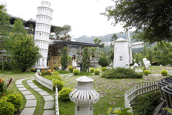 Visitors walk in a yard filled with paper structures at Carton King Creativity Park in Taichung, central Taiwan.