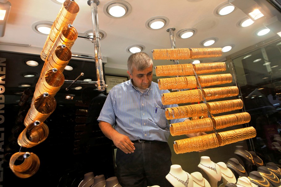 An employee arranges gold bangles at a jewellery shop. 