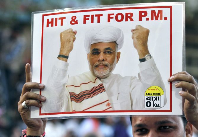 A supporter of India's main opposition Bharatiya Janata Party (BJP) holds a poster featuring Narendra Modi during a jubilation ceremony outside the party office in the western Indian city of Ahmedabad.