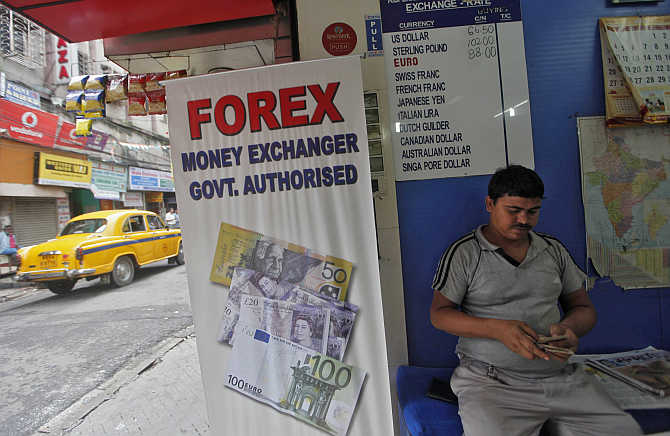 A customer counts currency inside a currency exchange shop in Kolkata.