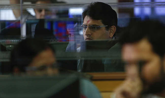 A broker monitors share prices while trading at a brokerage firm in Mumbai.
