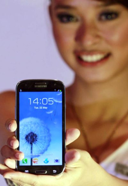 A woman presents the Samsung Galaxy SIII smartphone during its product launch in Jakarta.