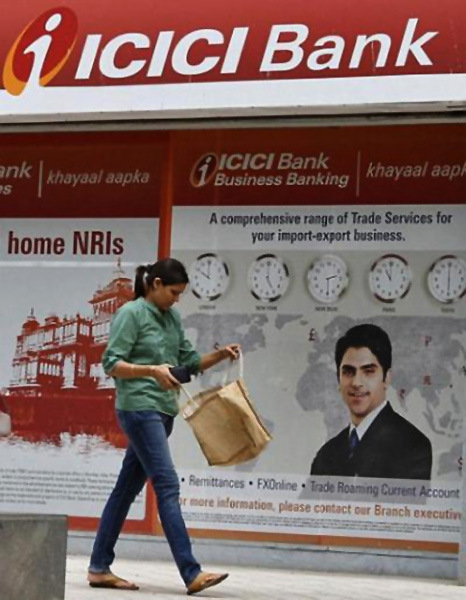 A woman passes by the ICICI Bank.