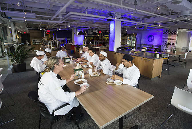 Food preparation team sit down to eat at the Google office in Toronto, Canada.