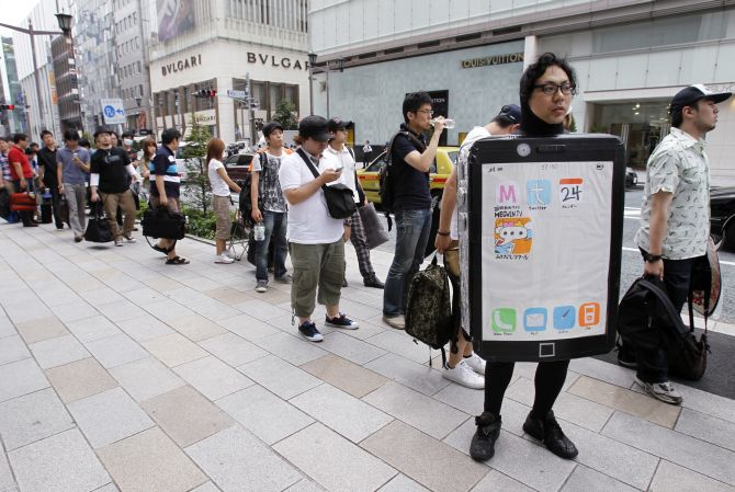 Customers waiting for the release of the new iPhone 4 line up outside Apple Inc's store in the Ginza district of Tokyo.