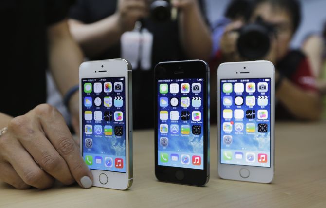 A staff member sets up the new iPhone 5Ss for a display picture at Apple Inc's announcement event in Beijing.