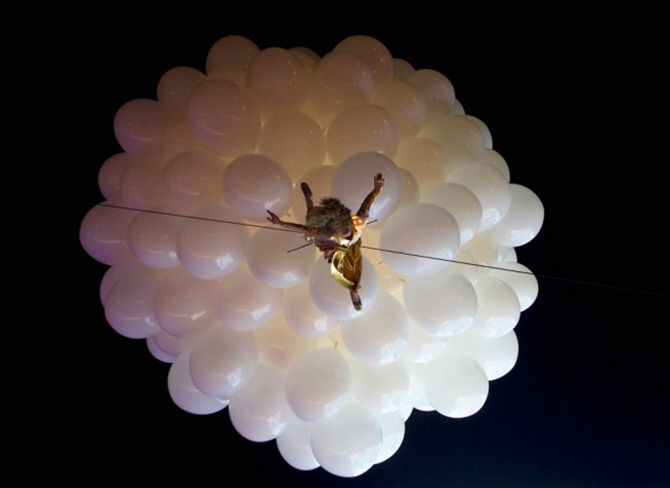 An artist hanging from balloons performs during the opening of Esentai Mall in Almaty, Kazakhstan.