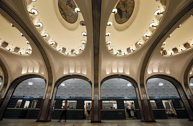 A woman walks on the platform as a train arrives at Mayakovskaya metro station in Moscow, Russia.