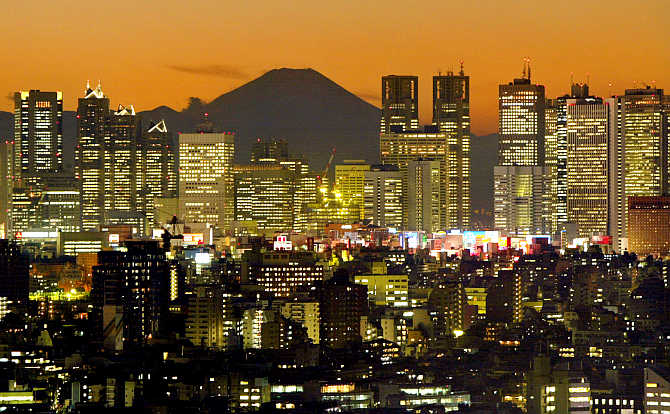 Skyscrapers in Tokyo's Shinjuku district frame Mt Fuji at dusk in Japan.