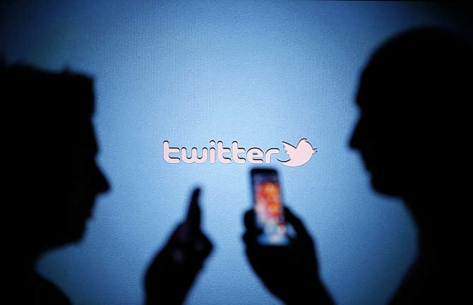 Men are silhouetted against a video screen with a Twitter logo in the central Bosnian town of Zenica.