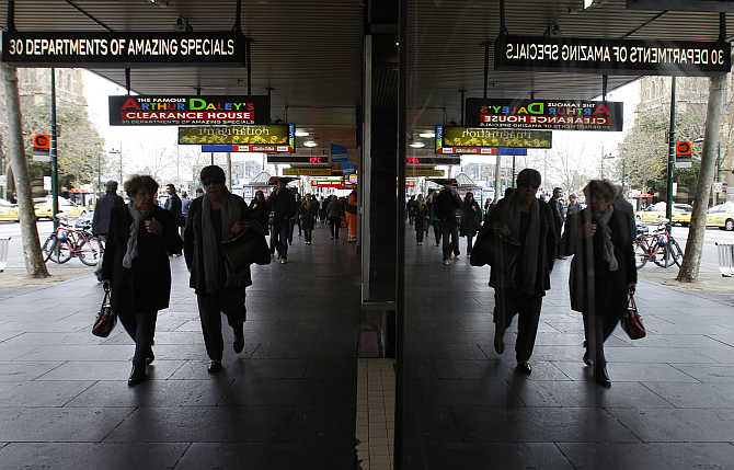 Pedestrians walk past shops in central Melbourne, Australia.