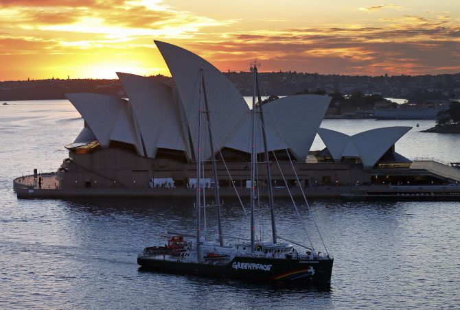 The new Greenpeace Rainbow Warrior ship navigates past the Sydney Opera House.
